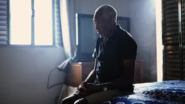 一位年长的非洲裔美国老年人坐在床边沉思地凝视着 — 图库视频影像