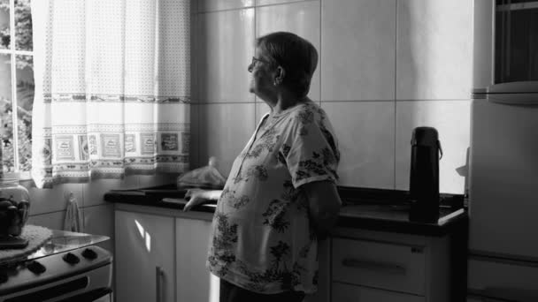 Monochromatyczna Staruszka Stojąca Domu Wyglądająca Przez Okno Szczera Starsza Pani — Wideo stockowe