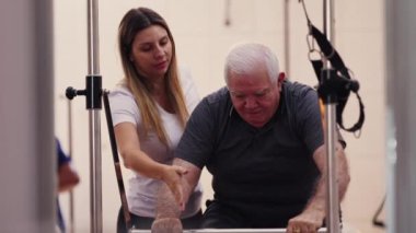 Yaşlı beyaz adam pilates koçunun yardımıyla esneklik ve dayanıklılık kazanıyor