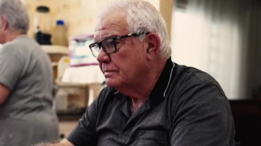 Kafkasyalı kıdemli adam Ev Mutfağı 'nda dizüstü bilgisayarla uğraşıyor, Modern Teknoloji' nin Ev Sahipleri 'nde geziniyor