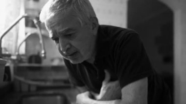 Evde Tek Renkli Çarpışma ve Çöküş Sahnesinde Tek Başına Yaşlı Adam Kalp krizi geçiriyor, siyah ve beyaz