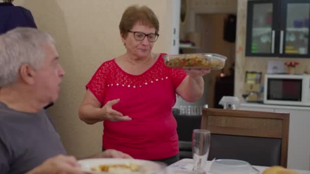 ランチ ギャザリングで高齢者のグループに食べ物を届けるシニアウーマン本格的なシーン — ストック動画