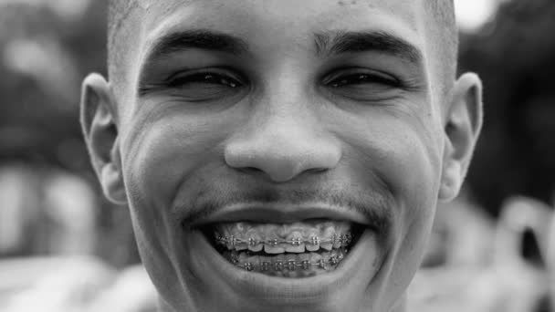 一个快乐的黑人年轻人穿着黑白单色的艺术夹子凝视着摄像机 快乐而有表现力的人凝视着对方的眼睛 — 图库视频影像
