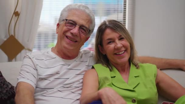 Glædelig Moden Par Smilende Griner Kamera Sidder Hjemme Sofa Ser – Stock-video