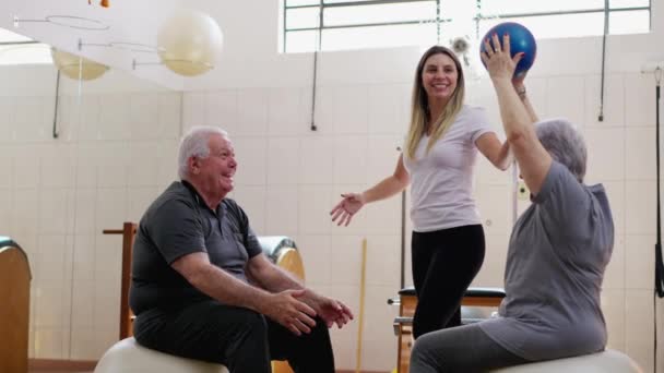 Ηλικιωμένο Ζευγάρι Που Ασχολούνται Την Άσκηση Γυναίκες Pilates Coach Κατά — Αρχείο Βίντεο
