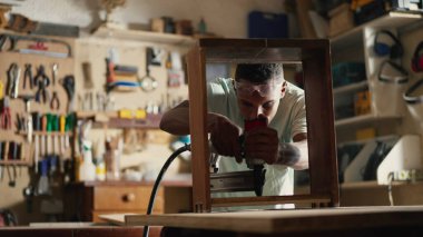 Marangozluk atölyesinde sondaj ekipmanları kullanan genç Kara Marangoz Mobilya Ustası