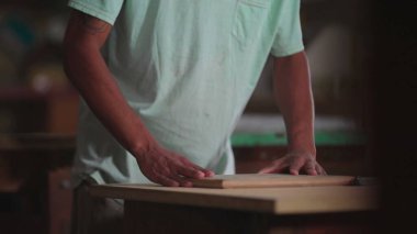 Marangozluk atölyesinde Odaklanmış Genç Brezilyalı Marangoz Ahşabı Kesiyor