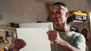 Marangozluk atölyesinde elinde cetvelle genç bir zenci. Stajyerlik mesleği konsepti