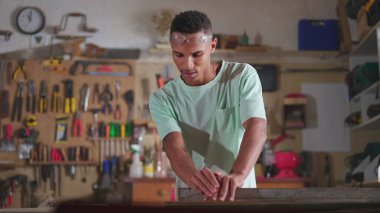 Marangoz gemisinde çalışan genç bir çırak endüstriyel ekipmanlarla odun kesiyor ve ölçüyor. El işi, iş mesleği konsepti olan kişiler