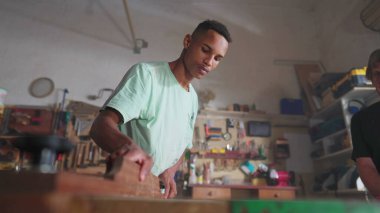 Marangozluk atölyesinde çalışan genç marangoz çırağı, yakın plan el bükme düğmesi. Meslek iş yeri kavramı