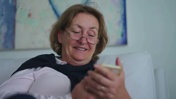 Счастливая Пожилая Женщина Держит Телефон Смотрит Смешное Видео Онлайн Пожилая — стоковое фото