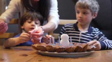 Doğum günü kutlaması, çocukların 8 yaşındaki çocuk kutlaması sırasında mum yakması. Pastanın önünde iki kardeş.