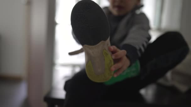ドアフロントエントランスで靴を履く小さな男の子 外出する準備をしている子供 外出する準備 — ストック動画