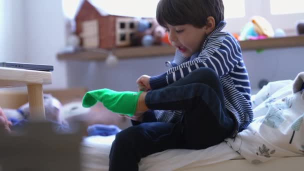 孩子们穿着袜子坐在床边 小男孩自己穿衣 孩子们准备开始一天的例行公事 — 图库视频影像