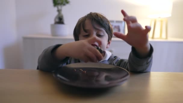 小さな男の子は プレートからブルーベリーケーキのスナックをつかむ 子供は砂糖を食べながら健康的な食べ物デザートを甘やかします — ストック動画