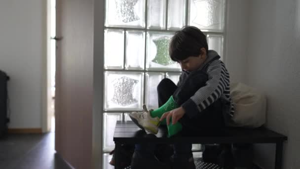 小男孩想把鞋子放在公寓门前 孩子们与袜子和鞋子作斗争 孩子不喜欢穿着时的感觉和烦躁 — 图库视频影像