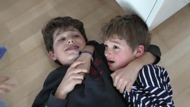 Αδέλφια Τσακώνονται Ξαπλωμένοι Στο Πάτωμα Παλεύουν Αδέρφια Καυγάδες Οικογενειακή Αντιπαλότητα — Αρχείο Βίντεο