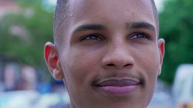 Mutlu bir siyah adam gökyüzüne bakıyor umutla ve inançla gülümsüyor. Neşe dolu Brezilyalı bir insanın yüz ifadesi. Minnettarlık duyuyor.