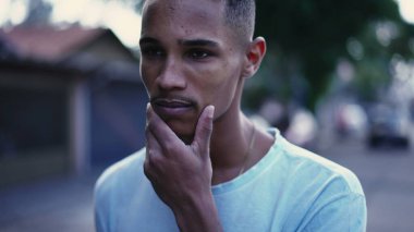 Derin zihinsel yansıması ve endişeli duygularıyla sokakta yürüyen dalgın bir siyah adam. Brezilyalı bir insanın şehir ortamında gezinirken ki hareketli görüntüsü