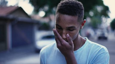 Derin zihinsel yansıması ve endişeli duygularıyla sokakta yürüyen dalgın bir siyah adam. Brezilyalı bir insanın şehir ortamında gezinirken ki hareketli görüntüsü