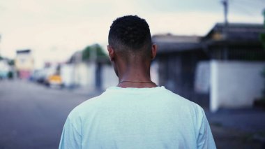 Derin zihinsel yansıması ve endişeli duygularıyla sokakta yürüyen dalgın bir siyah adam. Brezilyalı bir insanın şehir ortamında gezinirken ki hareketli görüntüsü