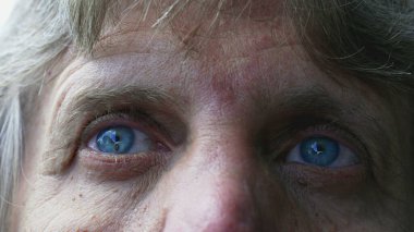 Üst düzey bir adam gökyüzüne bakıyor, mavi gözlü beyaz yaşlı bir adam düşünceli, düşünceli bir duyguyla bulutlara bakıyor.