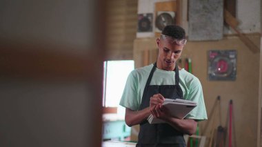 Marangozluk atölyesinde çalışan genç bir Brezilyalı marangoz. Mesleğiyle meşgul bir endüstri çalışanı