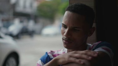 Düşüncelere dalmış dalgın bir siyah genç adam. Afro-Amerikan kökenli birinin düşünceli bakışları. Meditasyon zihinsel yansımasında yakın plan yüz.