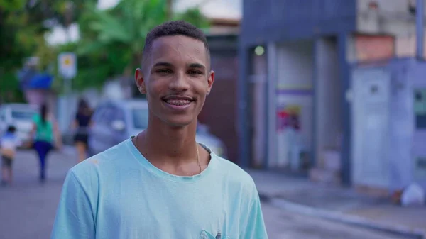 アーバンストリートシーンのカメラで笑う20代の本物の若い南アメリカ人男性 — ストック写真