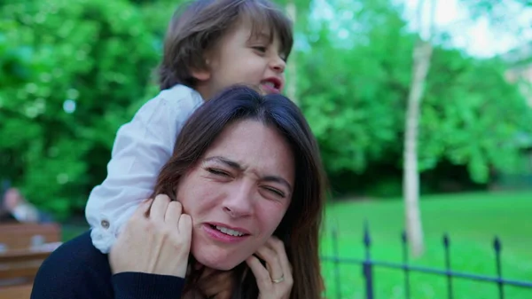 stock image Careless small boy choking mom while playing. Kid not knowing play limits, upset mother, real life