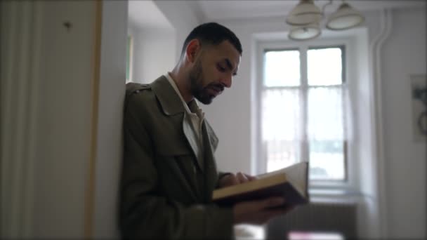 Een Geconcentreerde Arabische Man Verdiept Een Boek Terwijl Hij Binnen — Stockvideo