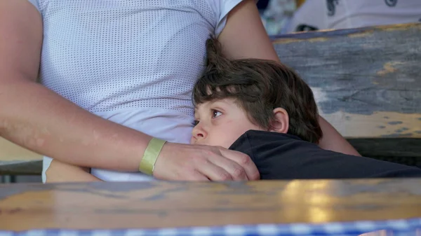 stock image Bored little boy clinging to mother's body with nothing to do, child struggles with boredom while holding into parent gazing at distance daydreaming