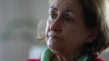 Konuşmayı dinleyen ve etkileşim halinde olan son sınıf bir kadının yakın çekimi. Kafkasyalı yaşlı kadın aktif olarak kamera önünde insanları dinliyor ve onlarla konuşuyor.