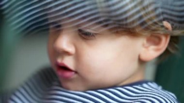 Sevimli çocuğun yakın çekimi, küçük çocuğun yüzü nesneyle etkileşime giriyor. 3 yaşında bir çocuk, çocukluk kavramı.