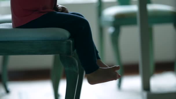 子供の足と足は椅子に座って かわいい小さな男の子は自宅でダイナーテーブルで食べ物を待っています — ストック動画