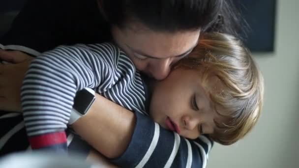 子供を受け入れる母親の心温まるシーン 暖かさと思いやりを与える腕に小さな男の子を抱いている母親の本物の母性ライフスタイルの瞬間 — ストック動画