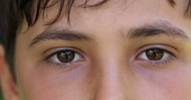 Boy closing and opening eyes close-up. Meditative Macro closeup of child eye looking to camera