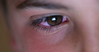 Boy eye staring at tablet screen playing video-game on tech, macro closeup eyes