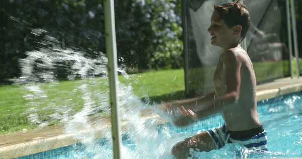 プールの水のプールの外の水の水しぶきで少年 子供は手で水を振りかける — ストック写真