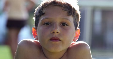 Boy reacting in shock to news with mouth open. Child looking to camera in disbelief and surprise