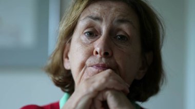 Yaşlı kadın konuşmak için eğiliyor, kıdemli kişinin yakın plan yüzü.