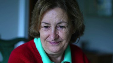 Mutlu bir son sınıf öğrencisi gülümseyen ve kameraya görünmeyen yaşlı bir kadının neşeli bir görüntüsü.