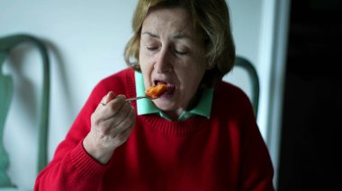 Kıdemli kadın sabahları papaya meyvesi yiyor. Yaşlı bayan kahvaltıda yemek yiyor.