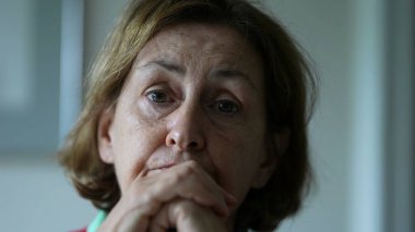 Yaşlı kadın konuşmak için eğiliyor, kıdemli kişinin yakın plan yüzü.