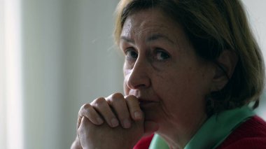 Yaşlı bir kadın kameraya doğru dönüyor, 70 'li yaşlarda yaşlı bir insanın yakın çekim yüzü emekliliği ve yaşlılığı gösteriyor.