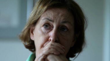 Konuşmayı dinleyen kıdemli bir kadın evet diyerek onaylıyor, yaşlı bir bayanın yakından çekilmiş yüzünü ciddi şekilde dinliyor kamera önünde olmayan birine odaklanıyor.