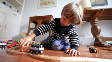 Çocuk evde antika tren setiyle oynuyor, Çocuk elinin Retro Railroad ile yakın çekimi