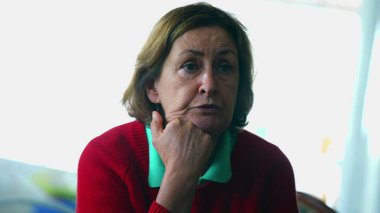 Konuşmaya katılan kıdemli kadın dikkatle konuşmacıyı dinliyor. Çenesi çenesinde samimi, yaşlı bir kadın hikayeye dalmış.