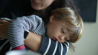 Annesinin çocuğunu kucakladığı, otantik annelik hayatı sahnesi. Anne kucağında küçük bir çocuğu kollarına alıp ona şefkat ve şefkat gösteriyor.