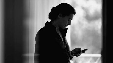 Tek renkli kadın sahnesi, akıllı telefon aygıtı kullanıyor cep telefonunda internet geziyor, ekrana bakan kişi...